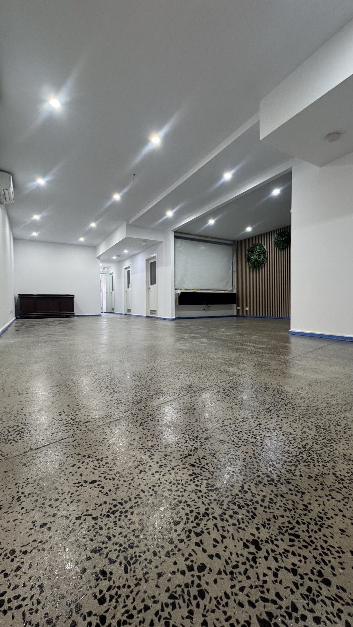 Charcoal grind and seal floor through an open commercial fitout, gloss